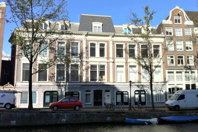 kantoorpand aan de gracht te amsterdam met uitkijk op the grand hotel
